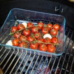 Verse tomaten met stelen grillen in glazen bakje op kamado bbq grill
