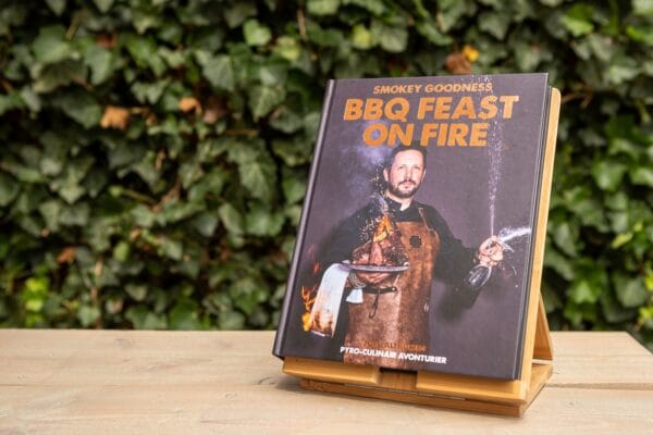 Smokey Goodness BBQ Feast on Fire kookboek op houten standaard in tuin