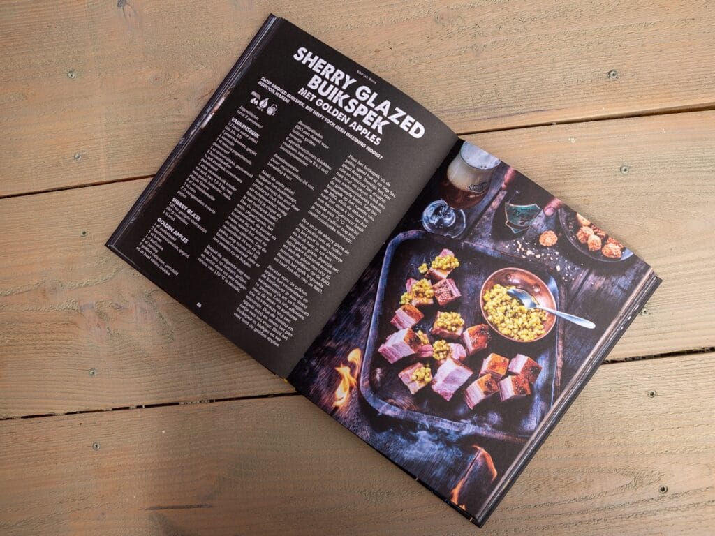 Open BBQ kookboek met recept voor Sherry Glazed Bult met Golden Apples op houten tafel.