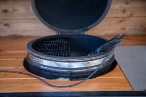 Geopende Kamado keramische BBQ grill met rooster en thermometer op houten terras