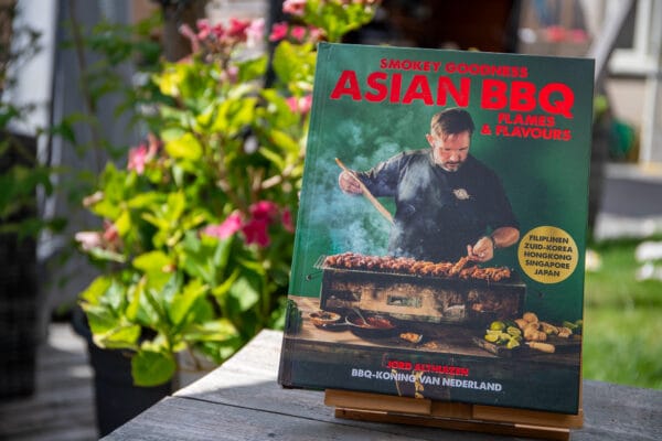 Smokey Goodness Asian BBQ kookboek op houten tafel met bloemen op achtergrond