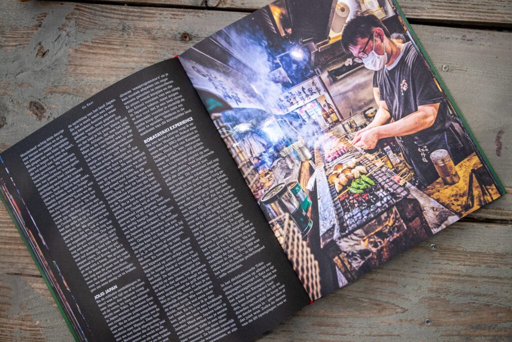 Opengeslagen magazine met artikel over Robatayaki-grillervaring en foto van man die voedsel bereidt op buitenkeuken