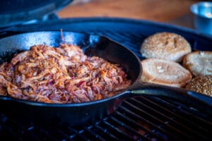 Shredded pulled pork in zwarte pan op kamado grill met sesambroodjes